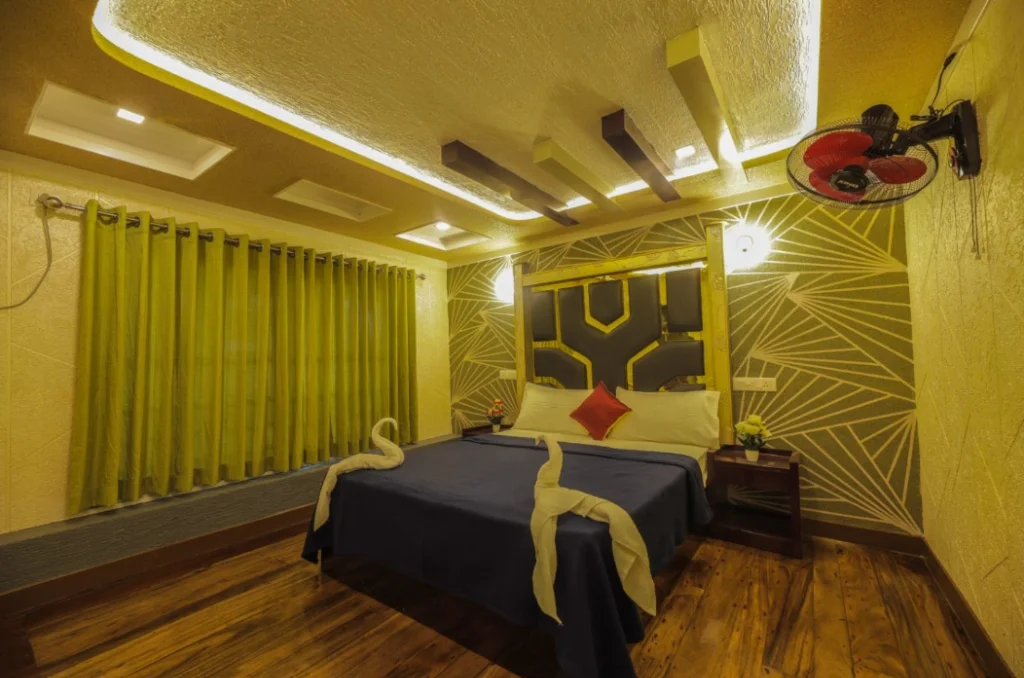 Deluxe air-conditioned bedroom with swan towel arrangement, wooden flooring, and ambient lighting