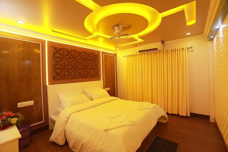 Luxury bedroom suite with diamond-quilted leather wall accent panel, circular ceiling illumination, and gold drapes