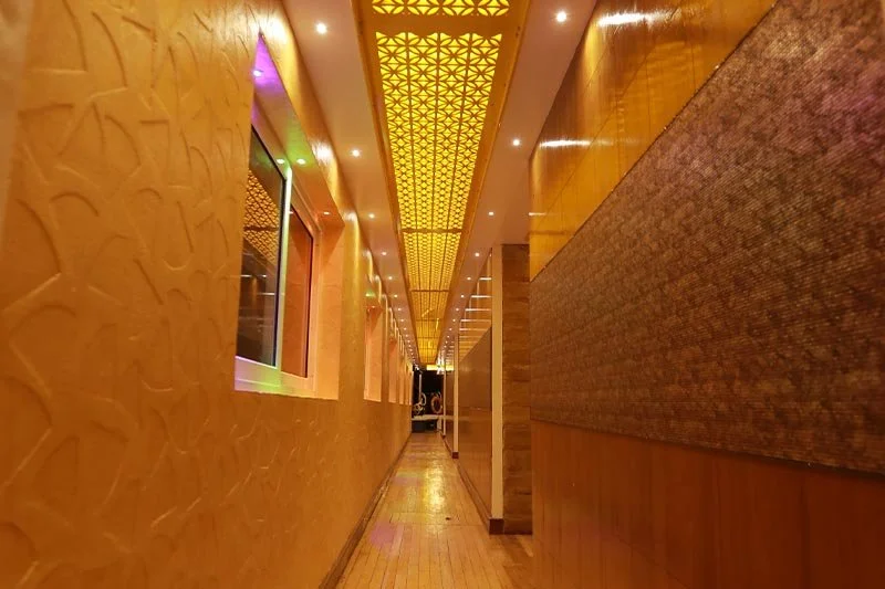 Long cabin deck hallway showing expansive length of the vessel with illuminated ceiling and multiple suite doors