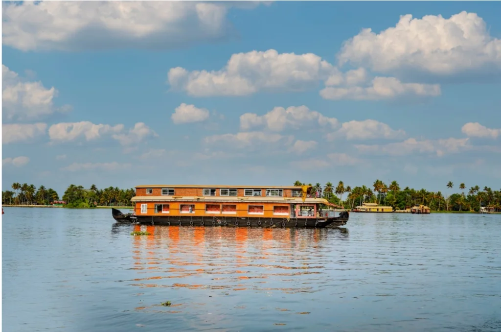 Scenic backwater cruise across open Vembanad waters with palm-fringed shoreline