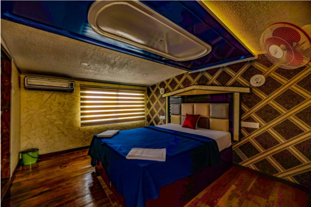 Deluxe air-conditioned bedroom with queen bed, ensuite bath, and warm lighting